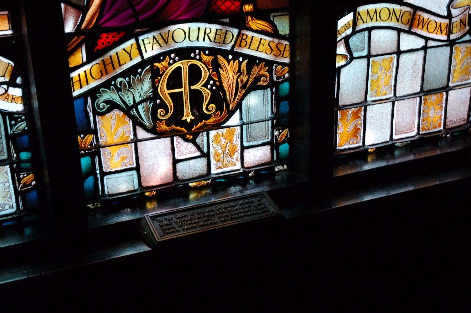 stained glass window detail: words on banner "highly favoured blessed... you among women"