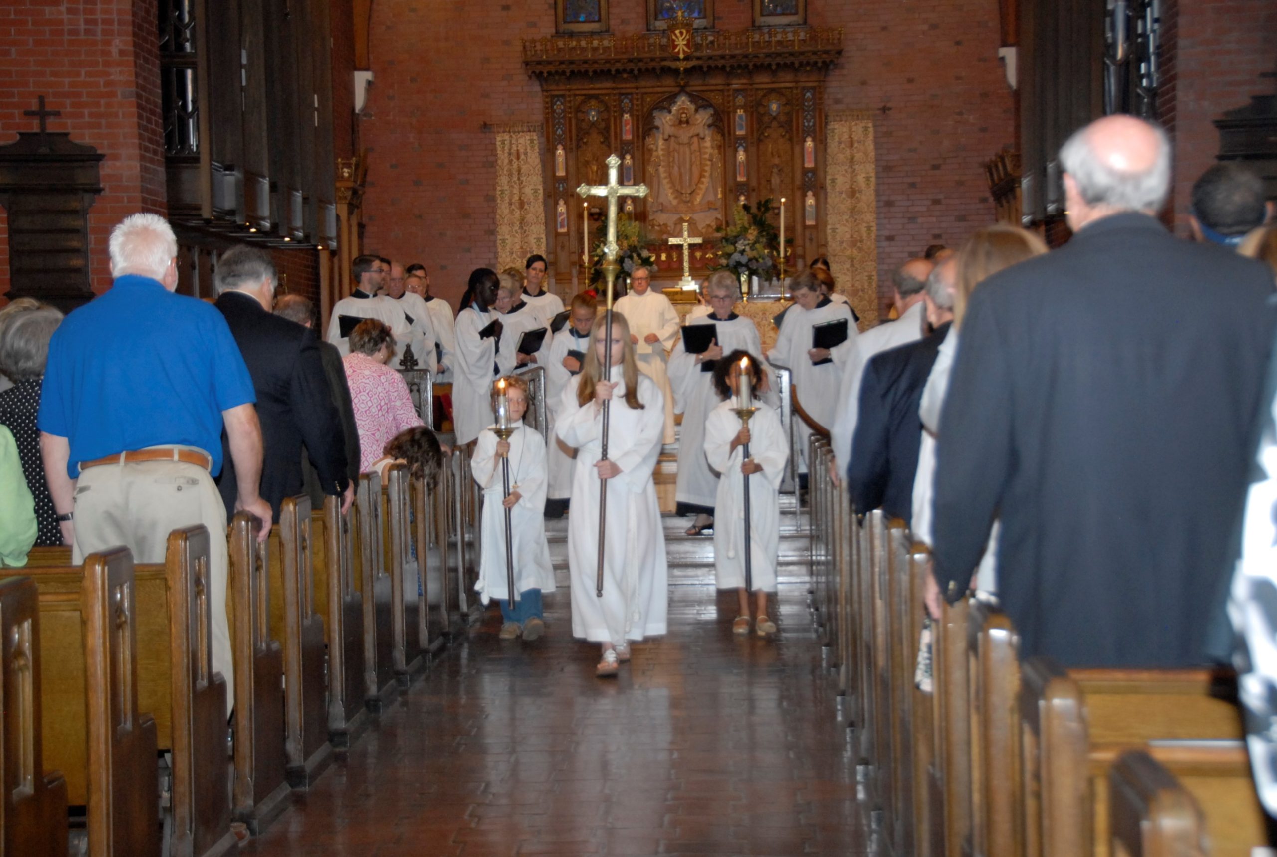 acolytes and crucifer lead procession out of church