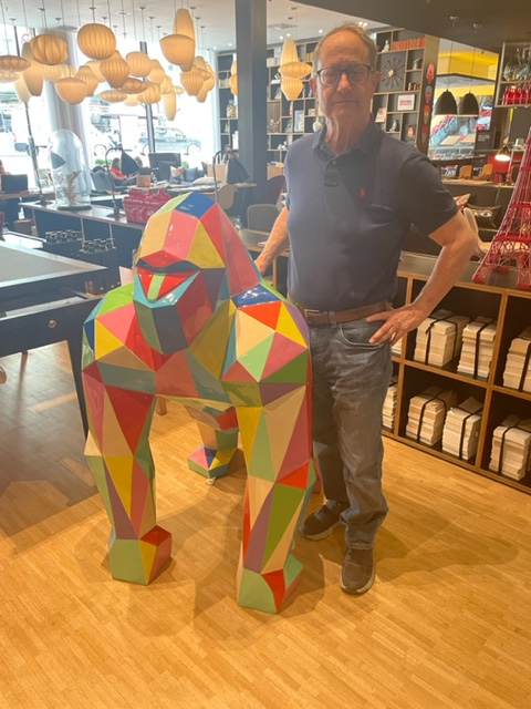 a man standing in a hotel lobby that contains many eclectic pieces of modern/contemporary art