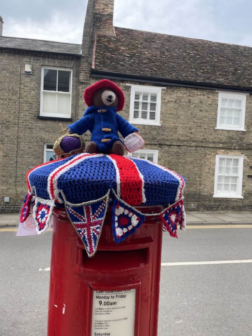 a British post box with crocheted coronation decoration on top