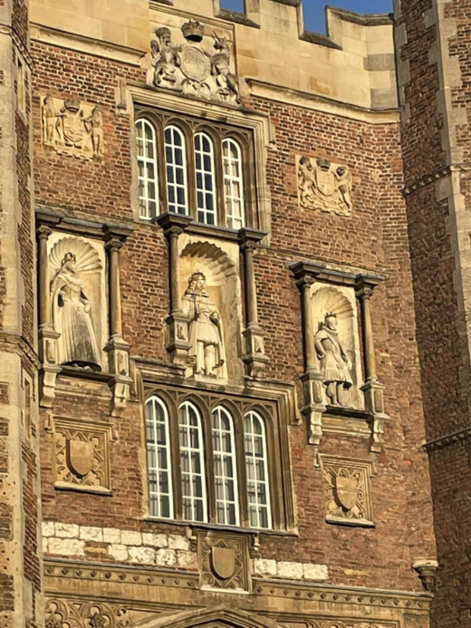 large stone statues inset into a wall with windows