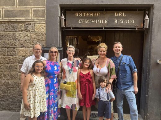 a group of adults and children outside a restaurant in a stone building